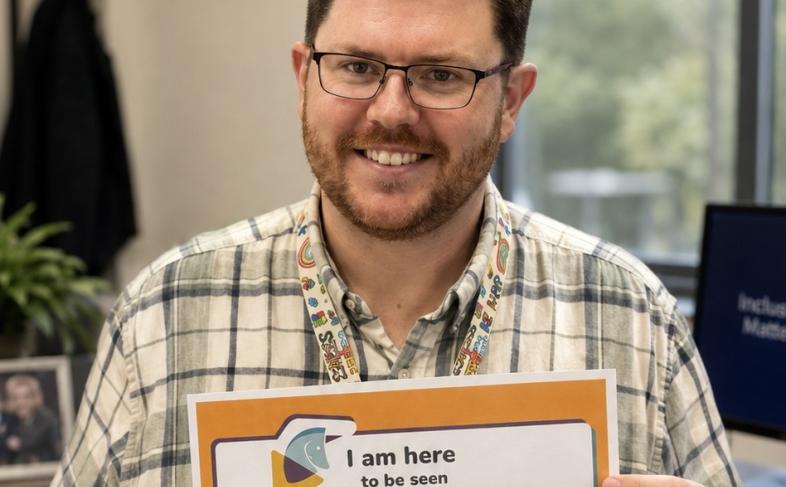 Social Worker Kieran holds up his pledge for Scottish Learning Disability Week