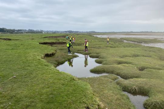 A coastal landscape with people in the distance 