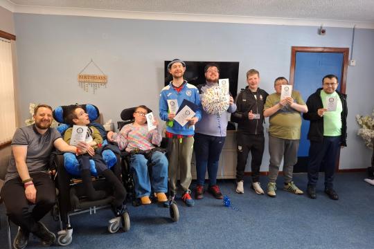 Service users at Stranraer ARC pose with their certificates of recognition. 