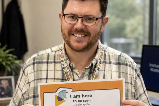 Social Worker Kieran holds up his pledge for Scottish Learning Disability Week
