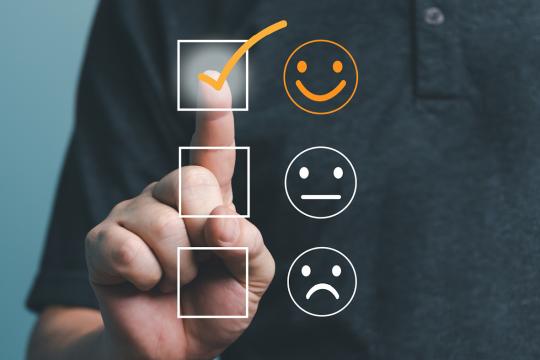 Person selecting a positive rating on a customer feedback survey.